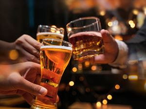 hands holding glasses of alcohol doing a