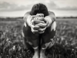 woman on ground hands clasped