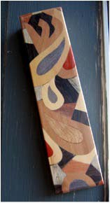 A beautiful Mezuzah by Israeli artist Yair Emanuel. Notice the Hebrew letter Shin (ש) on the design. Photo by Kenneth Freeman via Wikimedia CC