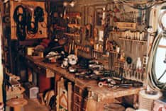 A photo of Poppy's shop, with several power tools displayed on his workbench.